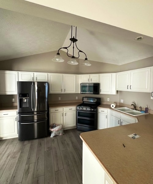 Kitchen with white cabinets, dark appliances and gray walls